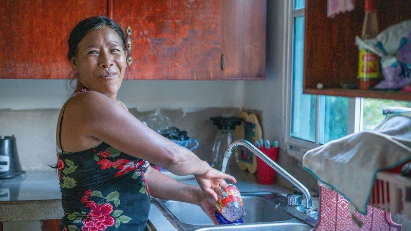 Señora Granadilla doing the dishes in her home in Honduras