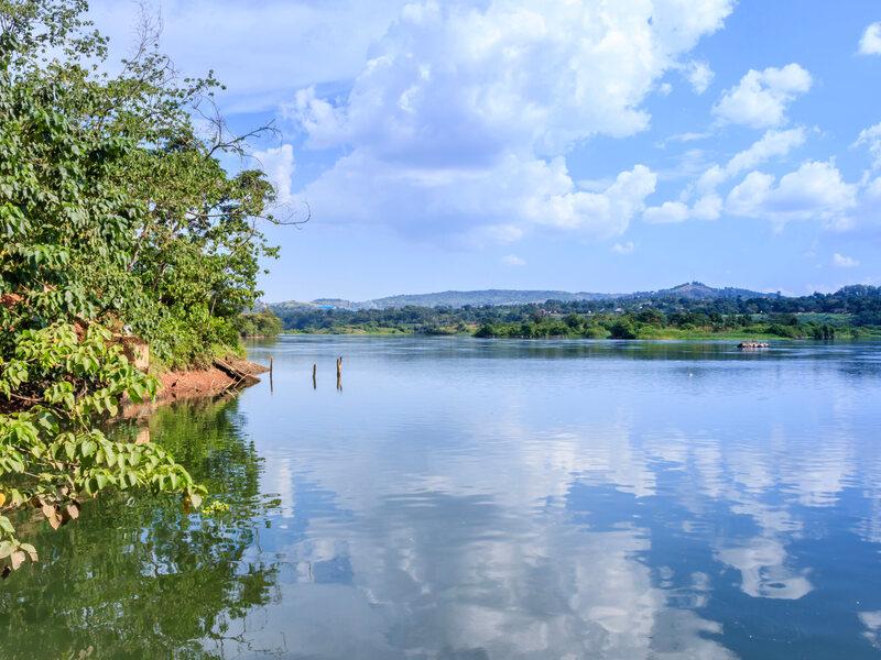Sunset view of the Victoria Nile river, with trees growing and the reflections on the water, Jinja, Uganda, Africa