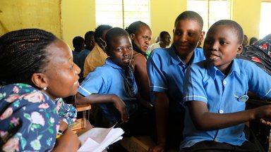 Woman visiting school class in Uganda