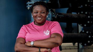 Woman in pink t-shirt with her arms folded looking into the camera