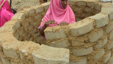 Woman building a latrine in Eritrea