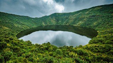Lake in volcano crater surrounded by vegetation