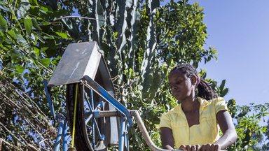 Woman fetching water with a rope pump at the compound of her home in Ethiopia