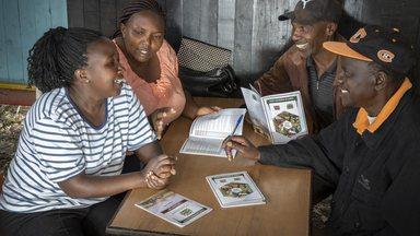 Two women and two men discussing around a table in Kajiado County Kenya