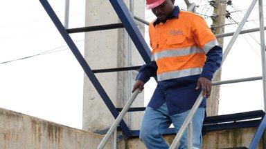 Technical officer walking down the stair at water tower in Asutifi North Ghana