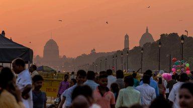 Crowd of people during sunset with government buildings in the background, New Delhi, India