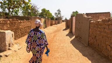 Woman walking in a street of the suburb of Ouagadougou (Burkina Faso)