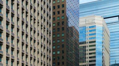 Tokyo, Japan - Oct 1 2024, A panoramic view of the glass facades of skyscrapers in Chiyoda district, with a blue sky and clouds in the background, at daytime,Tokyo