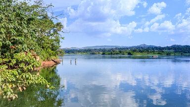Sunset view of the Victoria Nile river, with trees growing and the reflections on the water, Jinja, Uganda, Africa