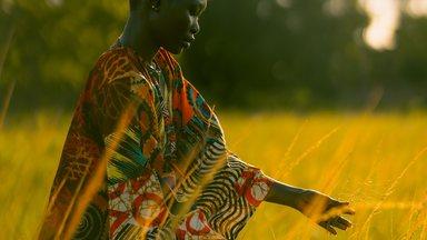 Woman with hands in grass creating a sense of motion