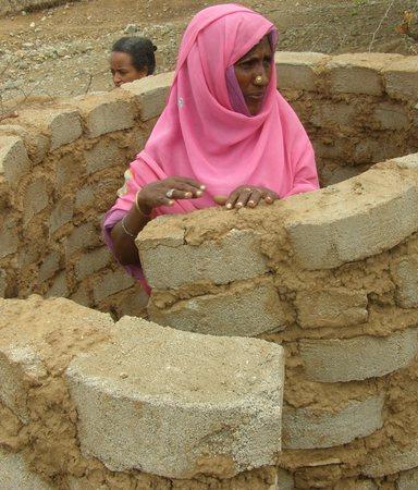 Woman building a latrine in Eritrea