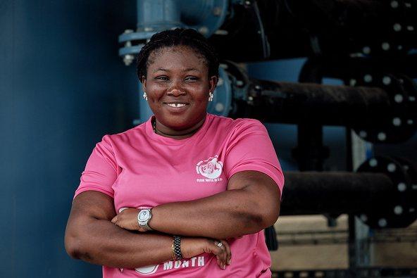 Woman in pink t-shirt with her arms folded looking into the camera