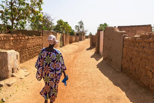 Woman walking in a street of the suburb of Ouagadougou (Burkina Faso)
