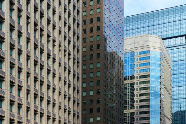 Tokyo, Japan - Oct 1 2024, A panoramic view of the glass facades of skyscrapers in Chiyoda district, with a blue sky and clouds in the background, at daytime,Tokyo