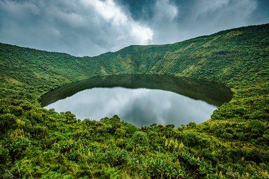 Lake in volcano crater surrounded by vegetation