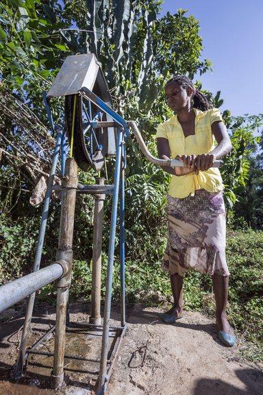 Woman fetching water with a rope pump at the compound of her home in Ethiopia