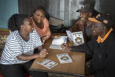 Two women and two men discussing around a table in Kajiado County Kenya