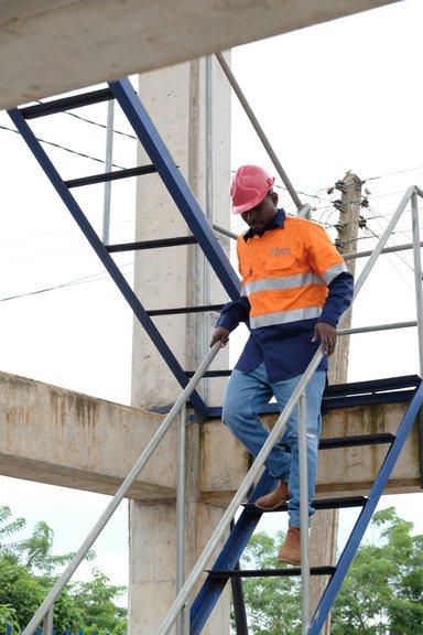 Technical officer walking down the stair at water tower in Asutifi North Ghana