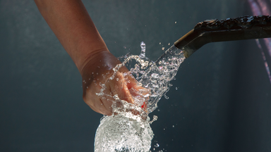 Hand under a tap sprinling water