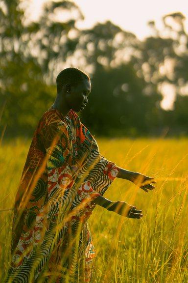 Woman with hands in grass creating a sense of motion