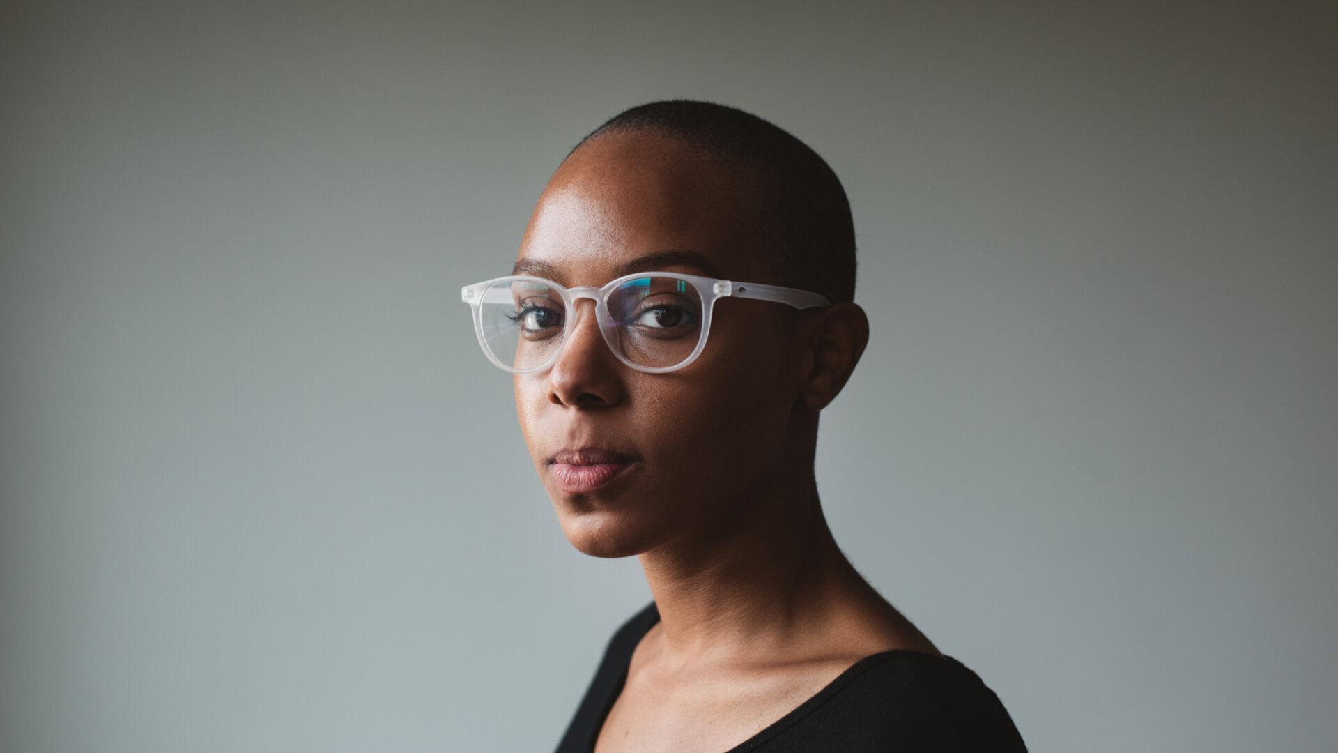 African woman with glasses looking into camera
