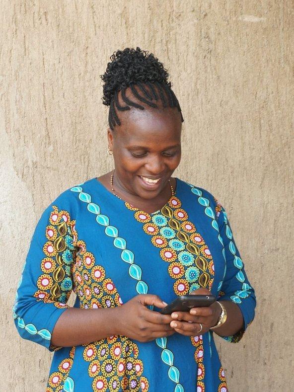 Stella Kewhiba looking at her phone
