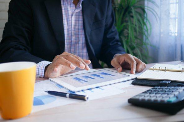 Man working on tablet making calculations