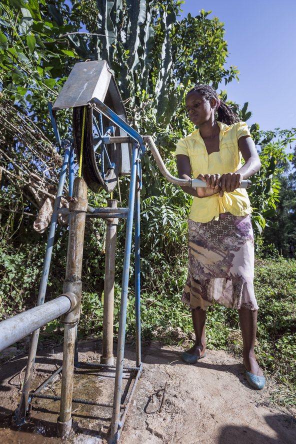 Woman fetching water with a rope pump at the compound of her home in Ethiopia