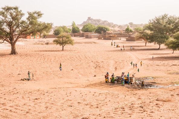Image of people gathering at water point in arid Sahel region